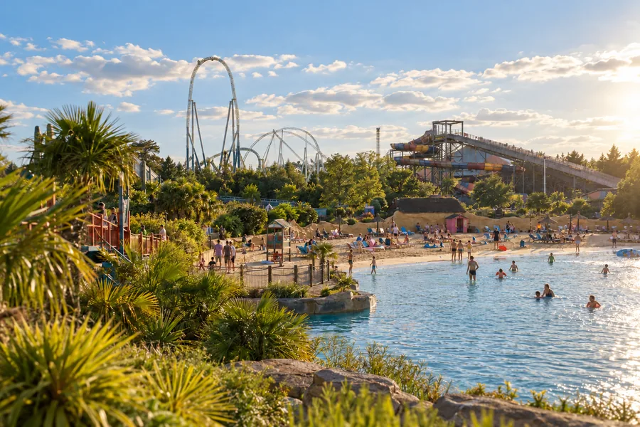 Giostre e attrazioni lungo l’acqua a Thorpe Park nella luce del pomeriggio